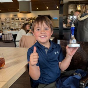 Trofee vastgehouden door een jonge golfer.