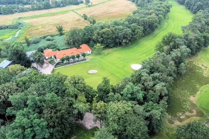 Luchtfoto van het clubhuis en de golfbaan van Golfclub De Dommel