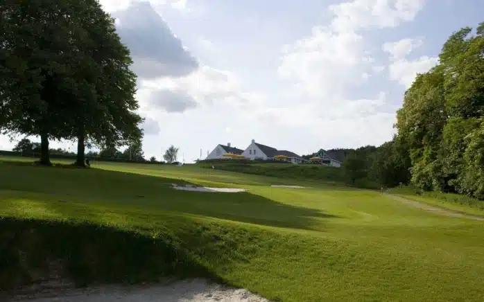 Par 3 oefengebied met clubhuis op de achtergrond bij Het Rijk van Nijmegen
