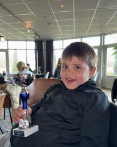 Trofee vastgehouden door een jonge golfer.