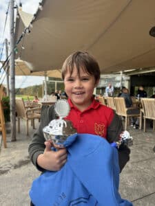 Trofee vastgehouden door een jonge golfer.