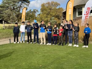 Groepsfoto van jeugdige golfers na toernooi op de green tijdens Dutch Kids Golf Tour.