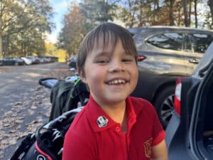 Jeugd golfer geniet van golfdag, glimlachend bij auto en golfuitrusting.