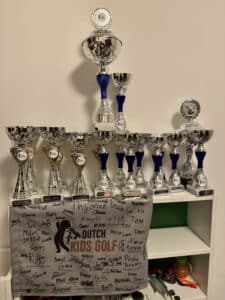 Prijzenkast met bekers en trofeeën van de Dutch Kids Golf Tour.