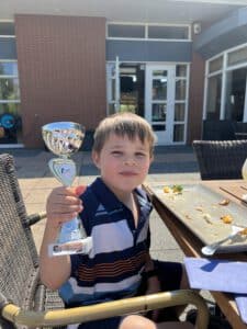 Trofee vastgehouden door een jonge golfer.