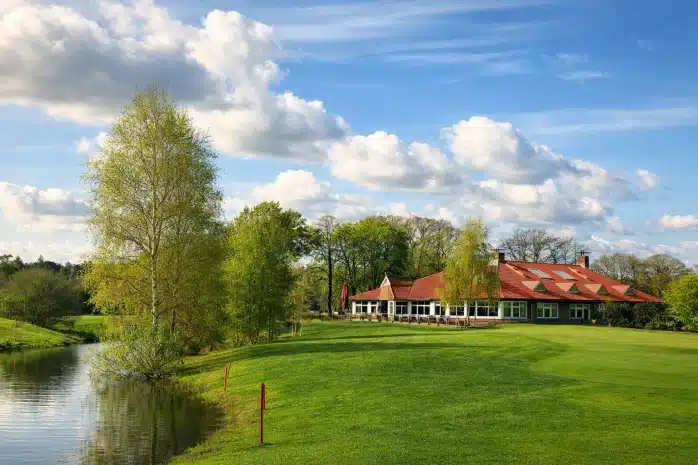 Clubhuis en green van de Twentsche Golfclub met waterpartij
